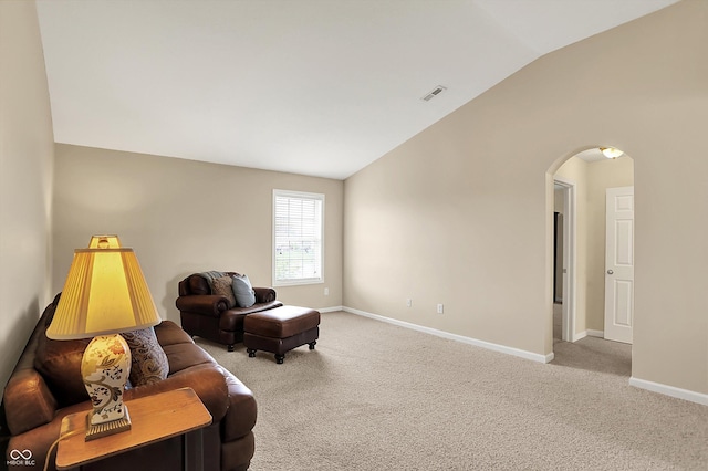living area featuring vaulted ceiling, arched walkways, carpet flooring, and baseboards