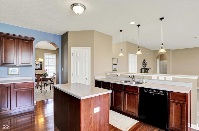 kitchen featuring dishwasher, a sink, arched walkways, and a center island