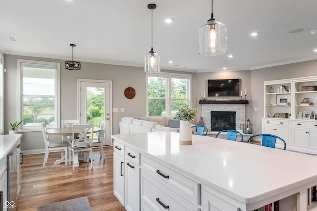 16270 Northwind Ct, Westfield, IN 46074 - kitchen with a stone fireplace, ornamental molding, light countertops, wood finished floors, and decorative light fixtures