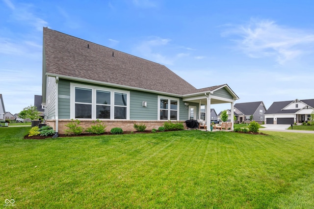 16270 Northwind Ct, Westfield, IN 46074 - back of house featuring brick siding, a lawn, central AC, and roof with shingles
