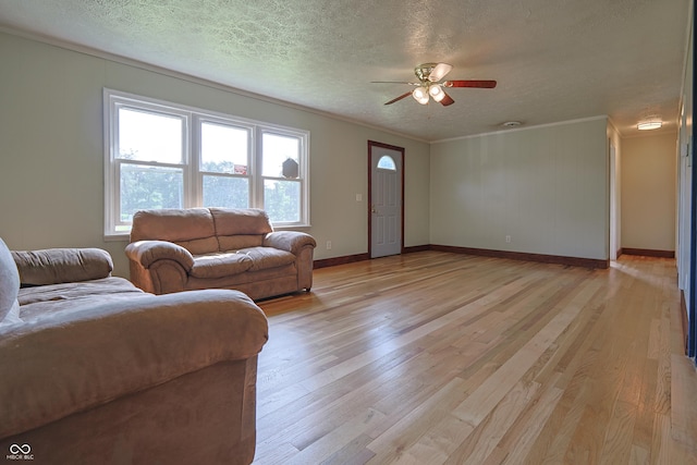 9855 N State Highway 7, Elizabethtown, IN 47232 - living room featuring light wood finished floors, a ceiling fan, a textured ceiling, ornamental molding, and baseboards