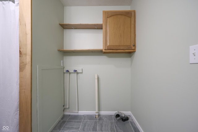 9855 N State Highway 7, Elizabethtown, IN 47232 - laundry area with cabinet space, washer hookup, baseboards, and dark tile patterned flooring