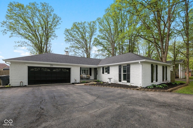 6673 Karyn Dr, Avon, IN 46123 - ranch-style home featuring a garage, asphalt driveway, brick siding, and a shingled roof