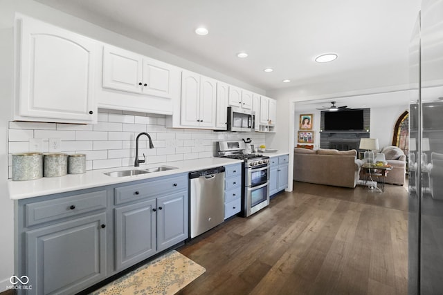 6673 Karyn Dr, Avon, IN 46123 - kitchen with stainless steel appliances, a sink, a ceiling fan, white cabinets, and dark wood finished floors