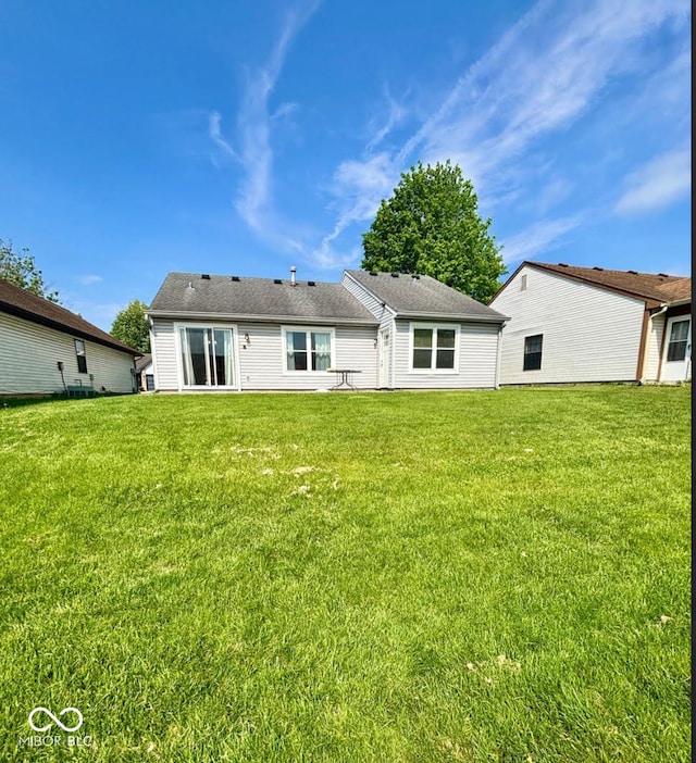 rear view of house featuring a yard