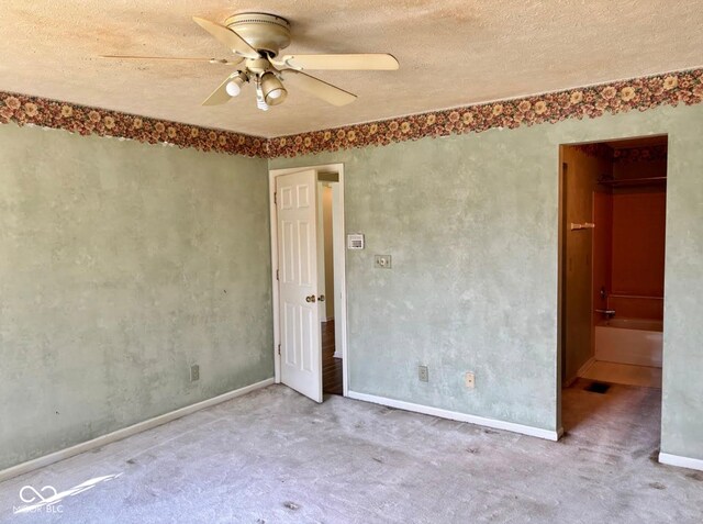 unfurnished bedroom with carpet floors, a textured ceiling, baseboards, and ceiling fan
