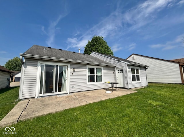 rear view of property with a patio, a yard, and a shingled roof