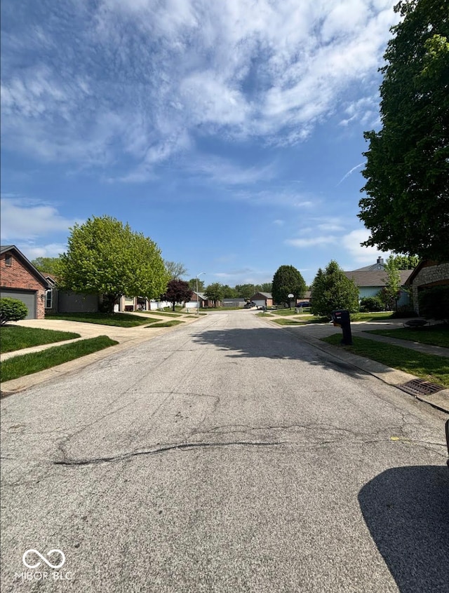 view of asphalt road featuring sidewalks and a residential view