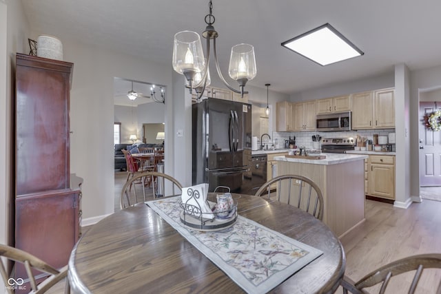dining area featuring light wood-type flooring, a ceiling fan, and baseboards