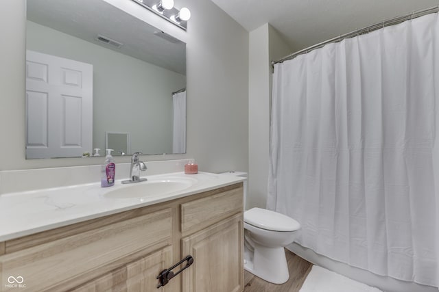 bathroom featuring toilet, vanity, wood finished floors, and a shower with curtain