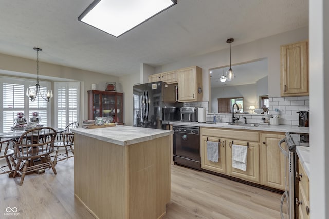 kitchen featuring black appliances, light brown cabinets, a sink, tasteful backsplash, and light countertops