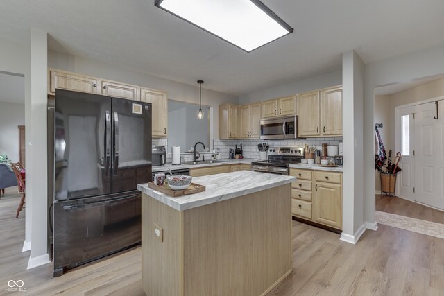 kitchen featuring stainless steel appliances, light brown cabinetry, a sink, a kitchen island, and decorative backsplash