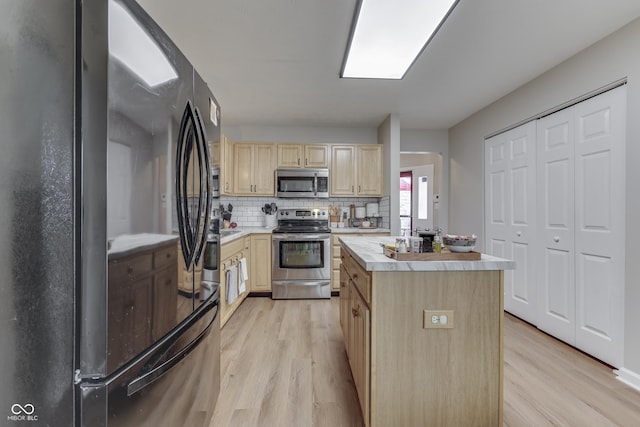 kitchen featuring stainless steel appliances, light brown cabinets, light wood finished floors, and light countertops