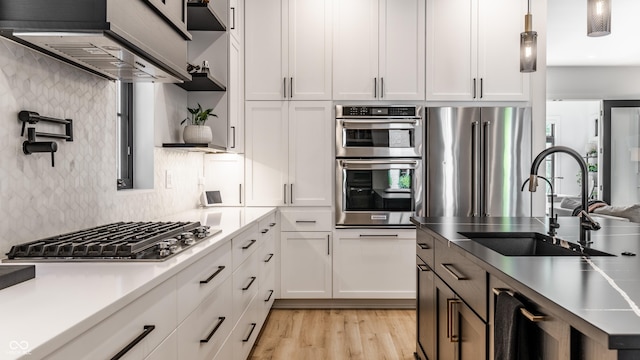 2036 Central Ave, Indianapolis, IN 46202 - kitchen featuring stainless steel appliances, a sink, ventilation hood, white cabinetry, and backsplash