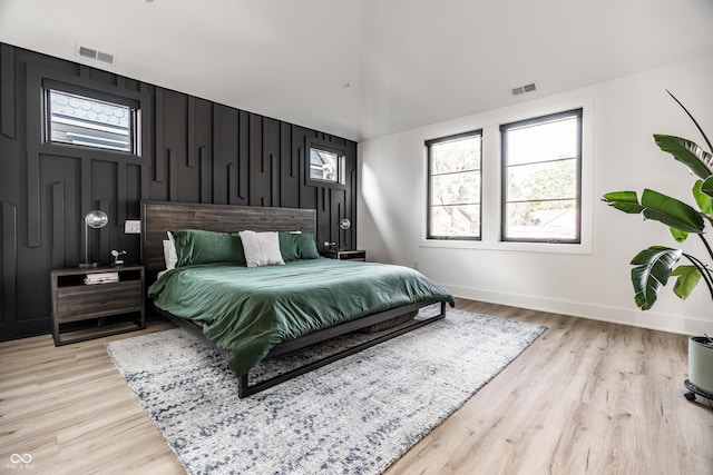 2036 Central Ave, Indianapolis, IN 46202 - bedroom featuring light wood finished floors, baseboards, an accent wall, and lofted ceiling