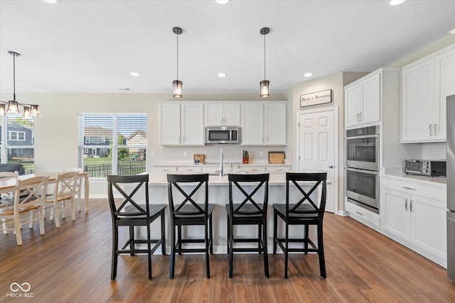 5375 Citadel Dr, Noblesville, IN 46062 - kitchen featuring appliances with stainless steel finishes, light countertops, dark wood-style flooring, white cabinetry, and recessed lighting