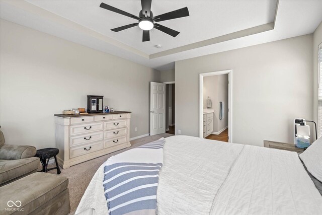 5375 Citadel Dr, Noblesville, IN 46062 - bedroom featuring a tray ceiling, baseboards, ensuite bathroom, and a ceiling fan