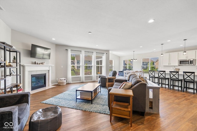 5375 Citadel Dr, Noblesville, IN 46062 - living area with plenty of natural light, wood finished floors, a tile fireplace, recessed lighting, and baseboards