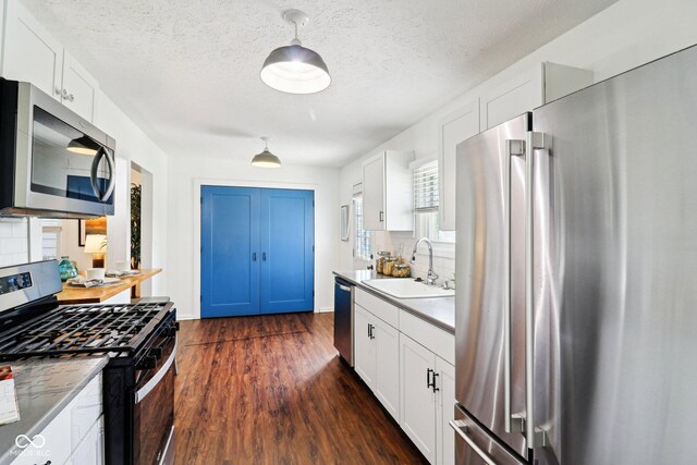 253 E Minnesota St, Indianapolis, IN 46225 - kitchen featuring appliances with stainless steel finishes, a sink, decorative backsplash, dark wood-type flooring, and white cabinets