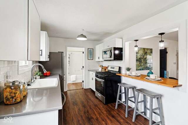 253 E Minnesota St, Indianapolis, IN 46225 - kitchen featuring appliances with stainless steel finishes, a sink, decorative backsplash, light countertops, and white cabinetry