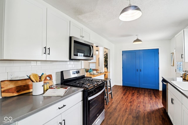 253 E Minnesota St, Indianapolis, IN 46225 - kitchen with stainless steel appliances, tasteful backsplash, dark wood-style floors, white cabinets, and a sink