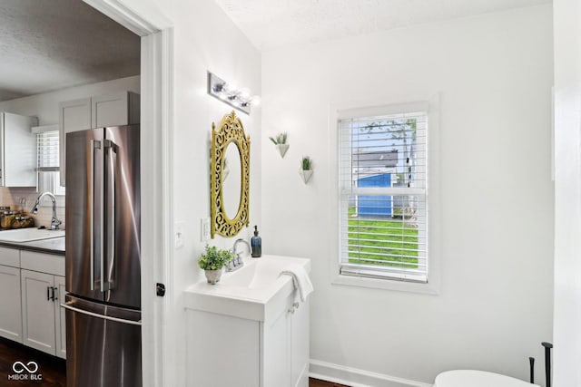 253 E Minnesota St, Indianapolis, IN 46225 - bathroom with a textured ceiling, healthy amount of natural light, two vanities, and baseboards