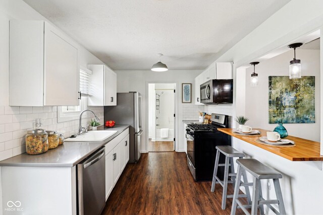 253 E Minnesota St, Indianapolis, IN 46225 - kitchen with appliances with stainless steel finishes, a sink, backsplash, and a kitchen bar