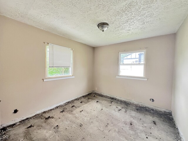 empty room with healthy amount of natural light and a textured ceiling