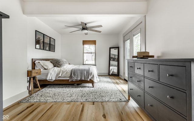 bedroom featuring light wood-type flooring, baseboards, and ceiling fan