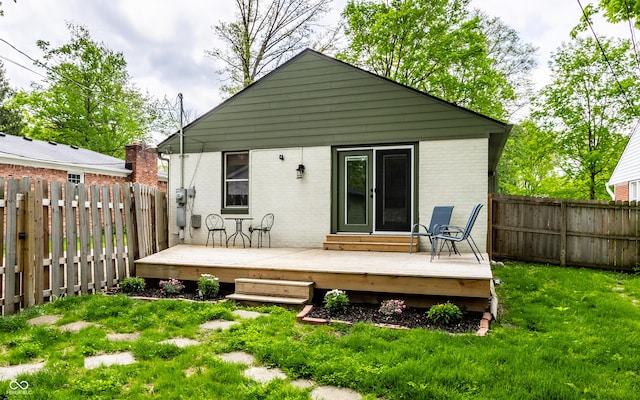 back of house featuring brick siding and a deck
