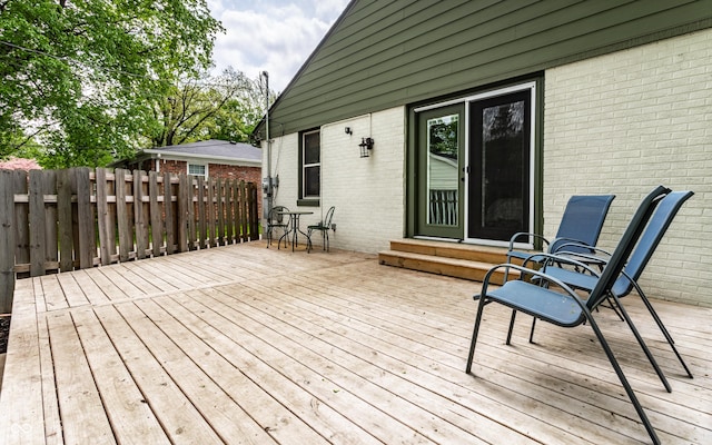 wooden terrace featuring entry steps and fence