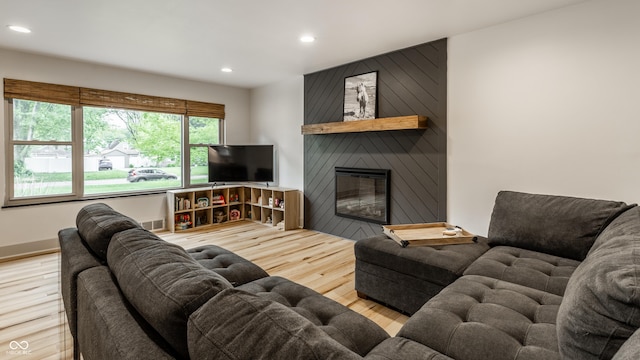 living area featuring wood finished floors, recessed lighting, and a large fireplace