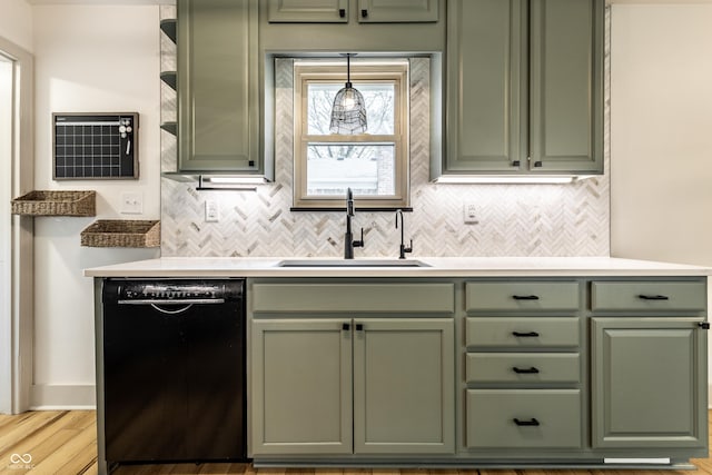 kitchen with green cabinets, black dishwasher, a sink, and backsplash