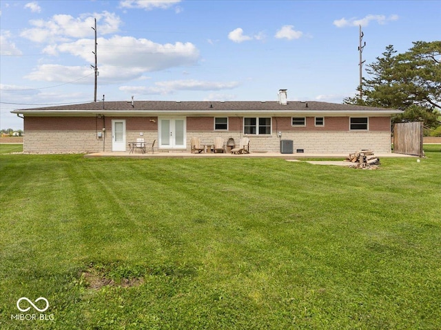 rear view of property with brick siding, a patio, cooling unit, a yard, and french doors