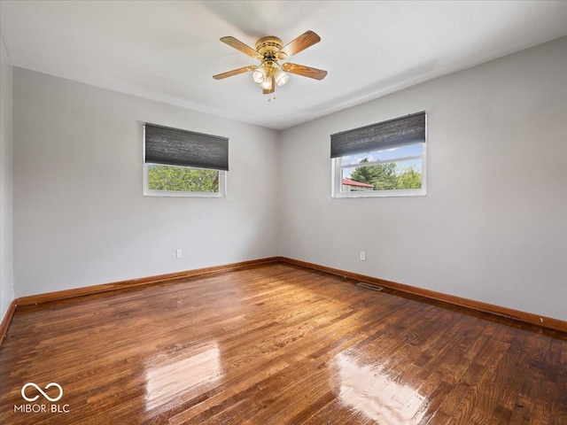 empty room with hardwood / wood-style flooring, baseboards, and a ceiling fan