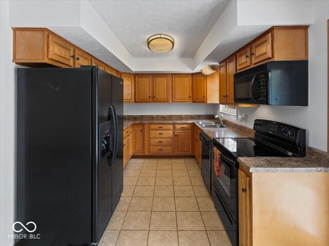kitchen featuring black appliances, a sink, light tile patterned floors, dark countertops, and a textured ceiling