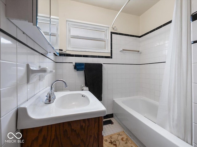 bathroom with tile patterned floors, tile walls, vanity, and shower / bathtub combination with curtain