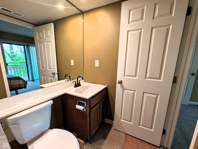 half bath with vanity, toilet, baseboards, and tile patterned flooring