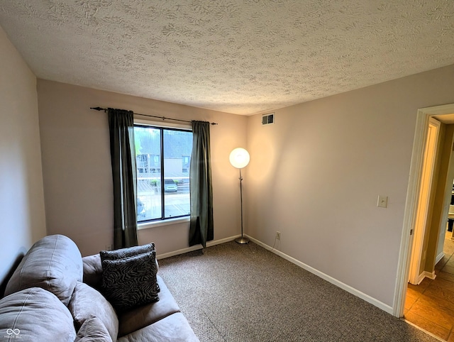 living room with carpet floors, a textured ceiling, and baseboards