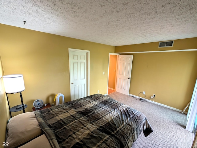 bedroom with carpet flooring, baseboards, and a textured ceiling