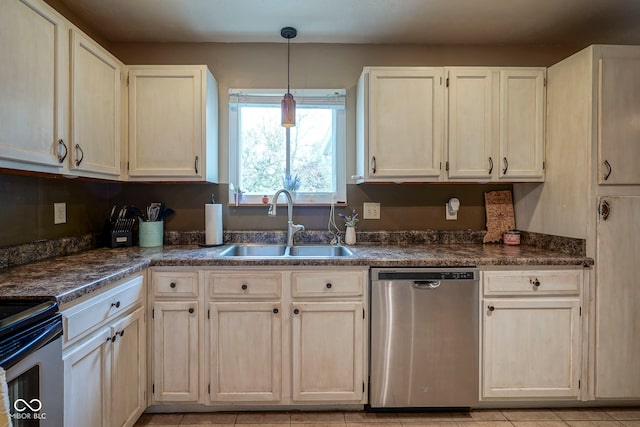 kitchen with appliances with stainless steel finishes, a sink, dark countertops, and decorative light fixtures