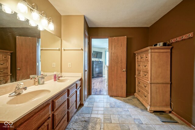 full bathroom with baseboards, double vanity, and stone finish flooring