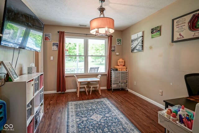 home office with dark wood-style floors, a textured ceiling, baseboards, and a chandelier