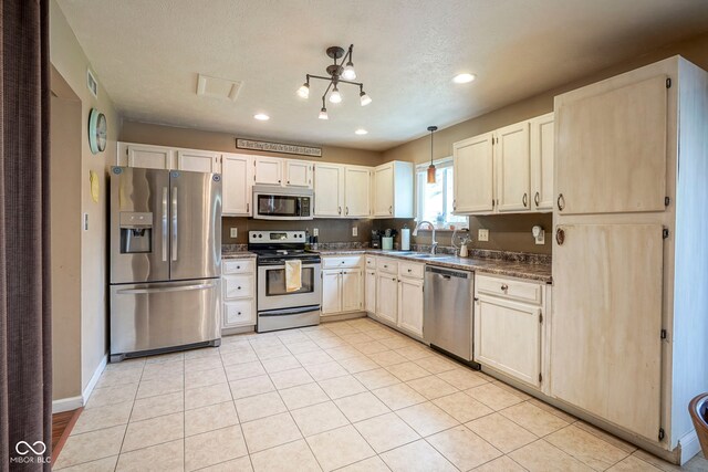 kitchen with appliances with stainless steel finishes, a sink, recessed lighting, dark countertops, and baseboards