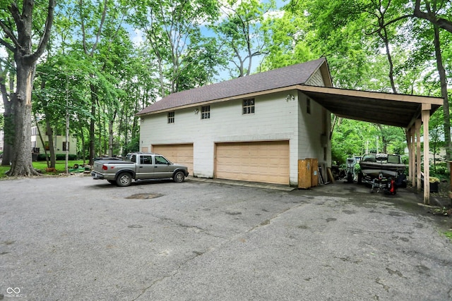 1530 E 75th St, Indianapolis, IN 46240 - view of side of property featuring a shingled roof and asphalt driveway