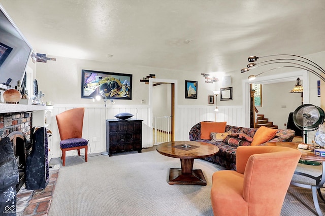 1530 E 75th St, Indianapolis, IN 46240 - living room featuring wainscoting, a brick fireplace, stairway, and carpet flooring