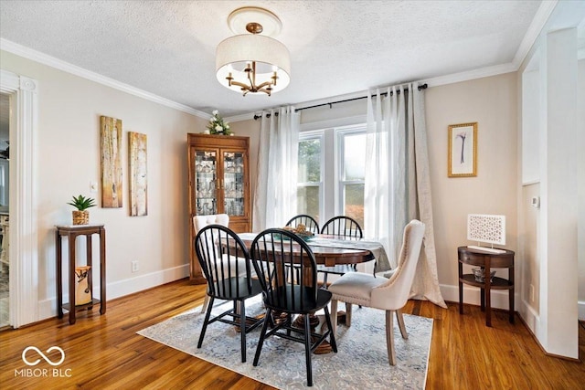 744 Gilbert Ave, Indianapolis, IN 46227 - dining room featuring baseboards, a textured ceiling, wood finished floors, ornamental molding, and a chandelier