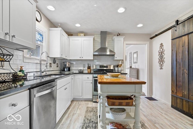 744 Gilbert Ave, Indianapolis, IN 46227 - kitchen featuring wall chimney exhaust hood, stainless steel appliances, a sink, backsplash, and white cabinetry