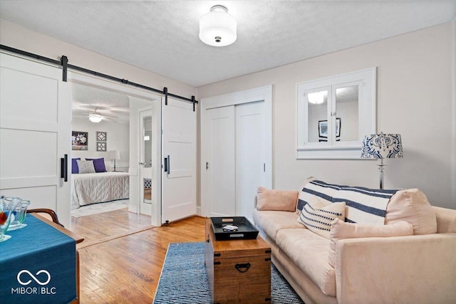 744 Gilbert Ave, Indianapolis, IN 46227 - living room with a barn door, a textured ceiling, and light wood-style floors