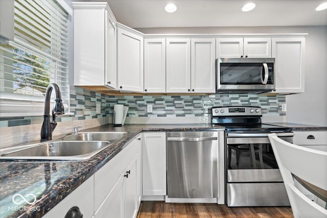 744 Gilbert Ave, Indianapolis, IN 46227 - kitchen with stainless steel appliances, a sink, white cabinetry, backsplash, and recessed lighting